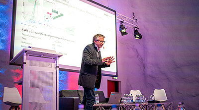 Der Referent ist in seinem Element während seiner Präsentation auf der Bühne im Steigersaal vom VersuchsStollen Hagerbach.